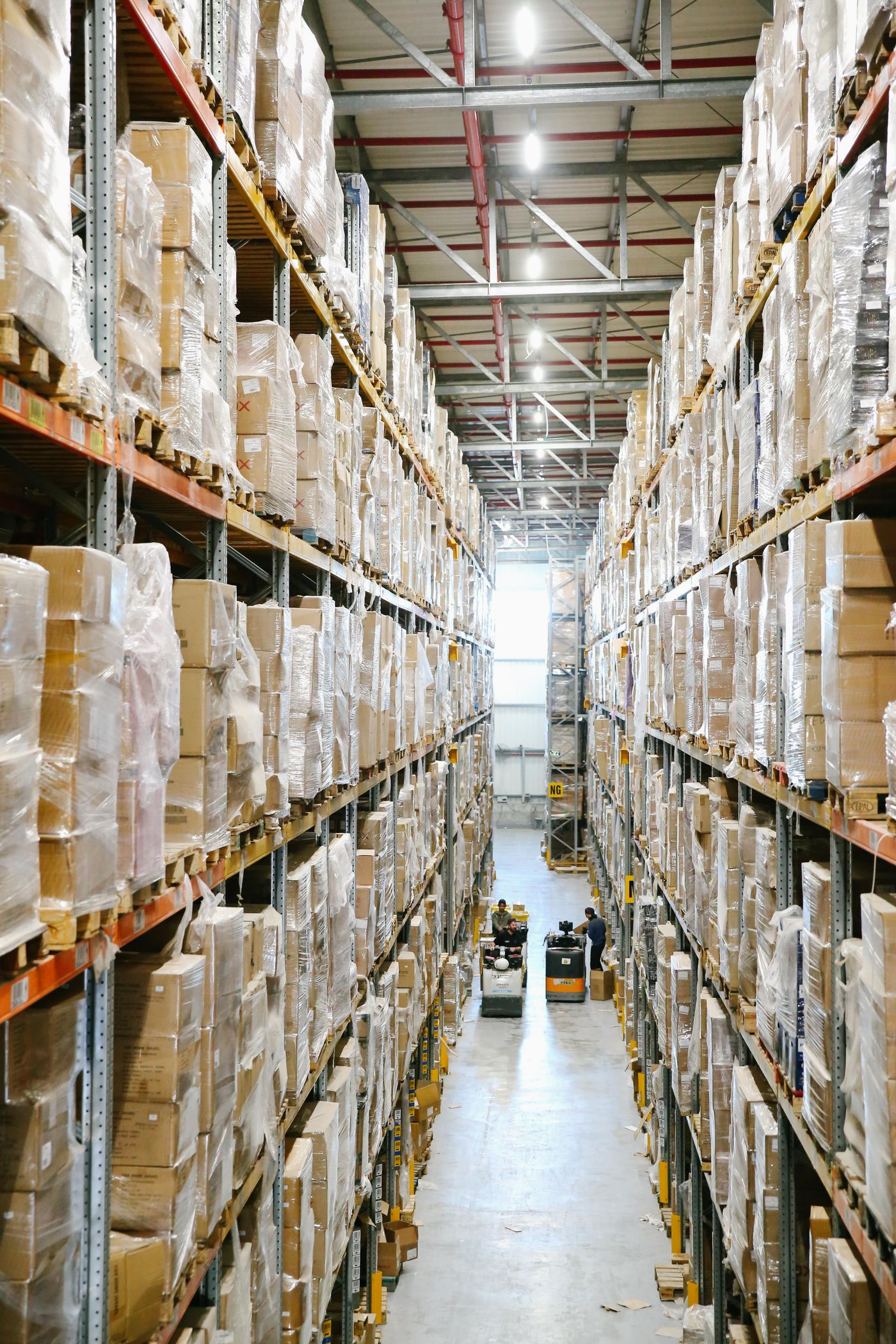 Estanterías para tarimas y mercancía envuelta en un almacén de distribución bien iluminado